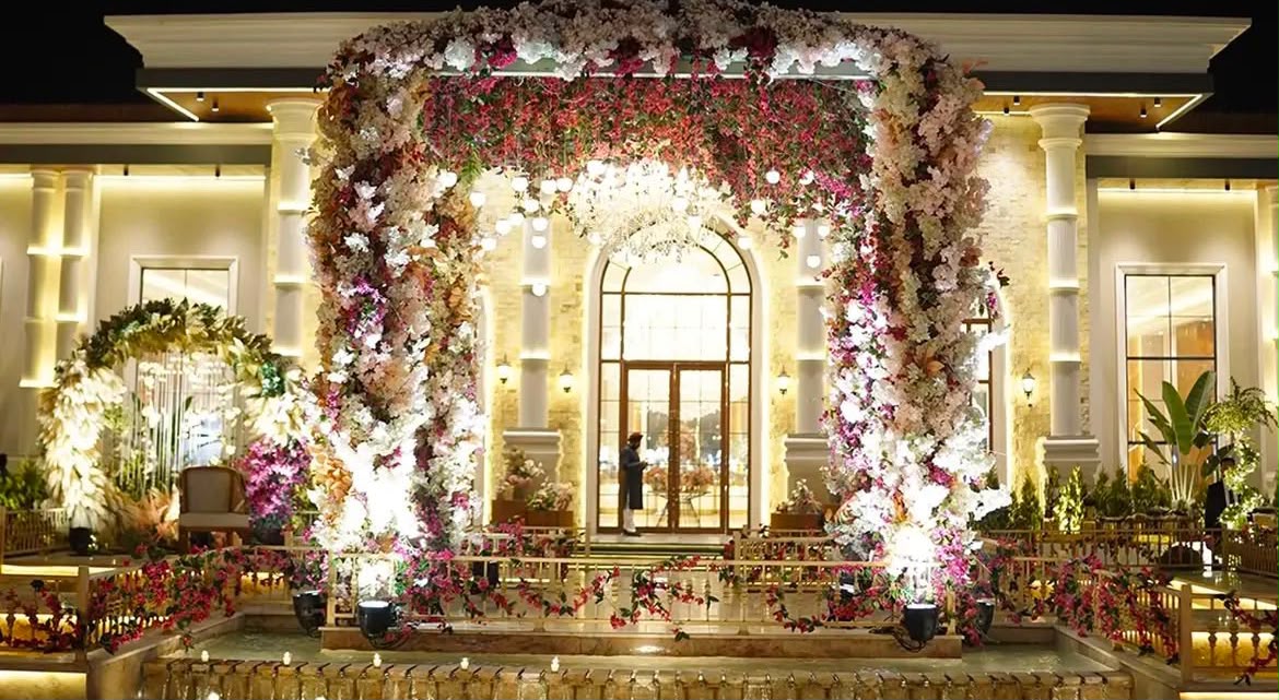 Illuminated floral entrance archway at the wedding venue at night