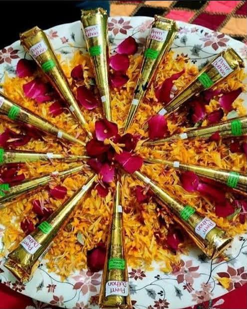 Decorated thali of henna cones with marigold petals and rose petals